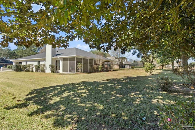 view of green lawn featuring a sunroom