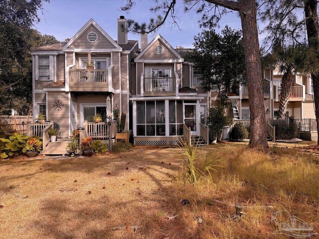 back of house with a balcony and a sunroom