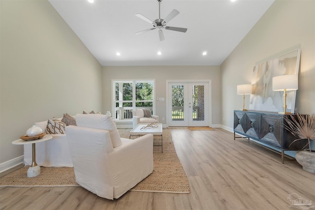 living room featuring light hardwood / wood-style flooring, ceiling fan, french doors, and vaulted ceiling