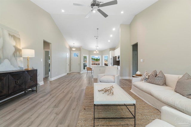 living room with light wood-type flooring, ceiling fan, and high vaulted ceiling