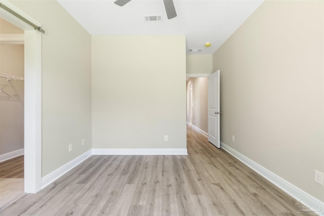 2098 Anna Ct, Milton, FL 32583 - unfurnished bedroom featuring light wood-style flooring, baseboards, a walk in closet, and ceiling fan