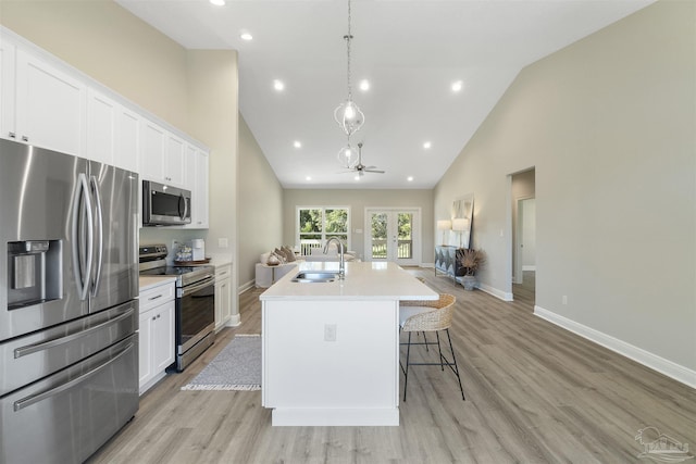2098 Anna Ct, Milton, FL 32583 - kitchen featuring stainless steel appliances, a sink, high vaulted ceiling, a kitchen island with sink, and white cabinetry