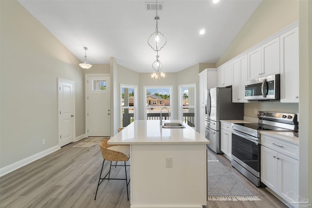 2098 Anna Ct, Milton, FL 32583 - kitchen with appliances with stainless steel finishes, a sink, vaulted ceiling, light wood-style floors, and a breakfast bar area