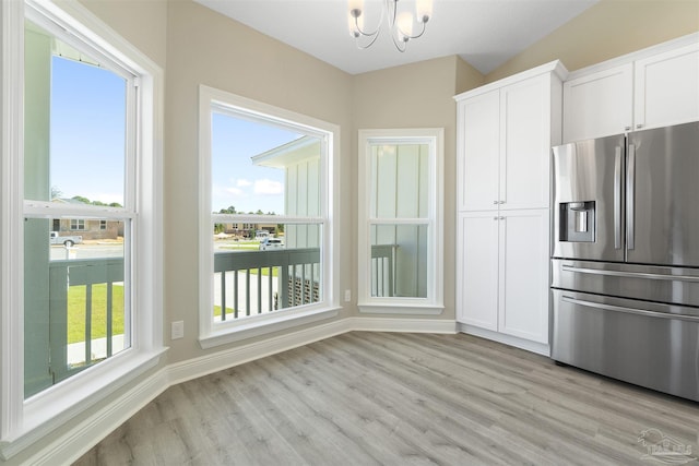 2098 Anna Ct, Milton, FL 32583 - kitchen featuring stainless steel fridge with ice dispenser, a chandelier, light wood-style floors, and white cabinetry