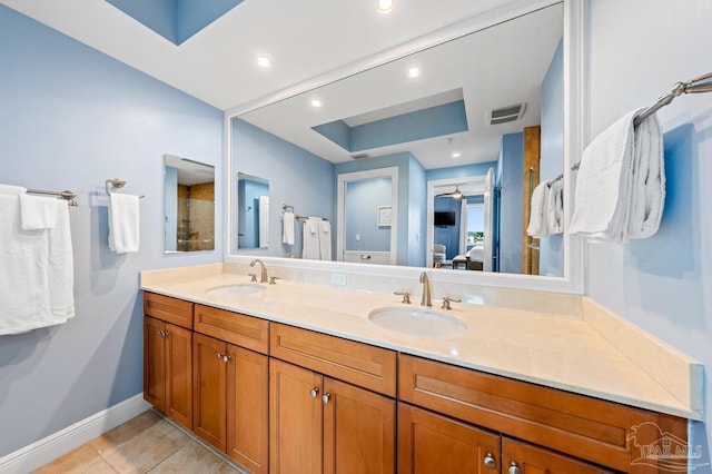 612 Lost Key Dr Unit 702-B, Pensacola, FL 32507 - bathroom with double vanity, tile patterned flooring, baseboards, a tray ceiling, and ensuite bathroom