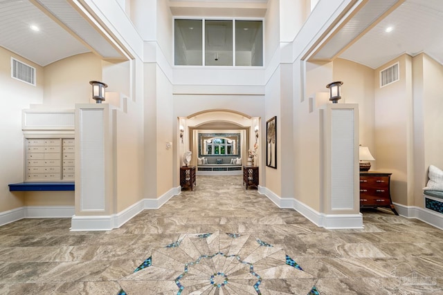 612 Lost Key Dr Unit 702-B, Pensacola, FL 32507 - hallway featuring baseboards, marble finish floors, recessed lighting, and a towering ceiling