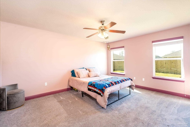 bedroom featuring a ceiling fan, baseboards, a textured ceiling, and carpet flooring