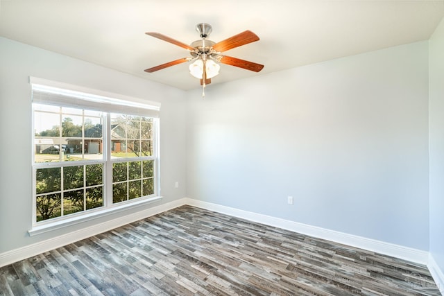 empty room with ceiling fan, baseboards, and dark wood-style floors