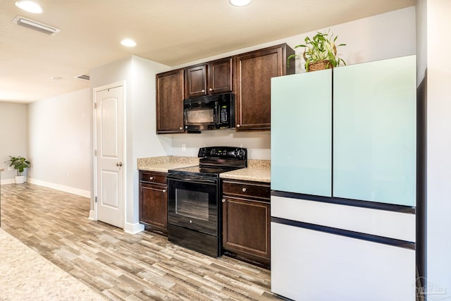kitchen featuring black appliances, visible vents, dark brown cabinetry, and light wood-type flooring