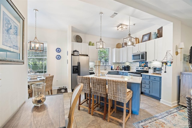 1430 Regency Rd Unit H103, Gulf Shores, AL 36542 - kitchen featuring appliances with stainless steel finishes, healthy amount of natural light, a breakfast bar, and backsplash