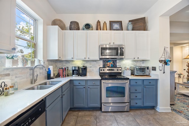 1430 Regency Rd Unit H103, Gulf Shores, AL 36542 - kitchen featuring appliances with stainless steel finishes, light countertops, white cabinets, and tasteful backsplash