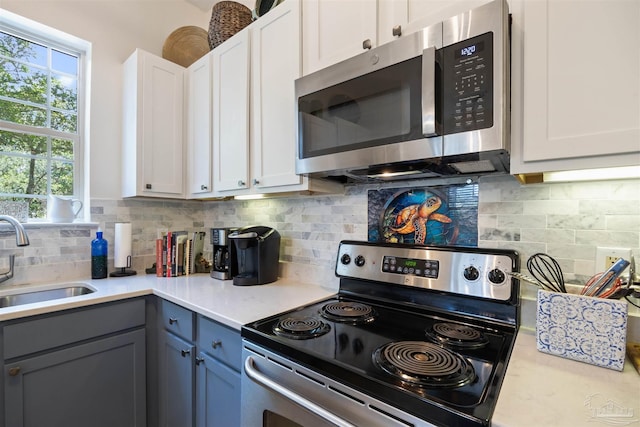 1430 Regency Rd Unit H103, Gulf Shores, AL 36542 - kitchen featuring stainless steel appliances, light countertops, white cabinets, decorative backsplash, and gray cabinetry