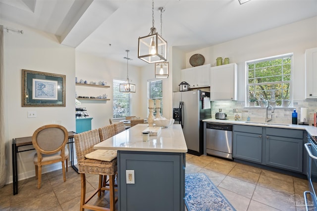 1430 Regency Rd Unit H103, Gulf Shores, AL 36542 - kitchen featuring stainless steel appliances, a kitchen bar, tasteful backsplash, light countertops, and a kitchen island