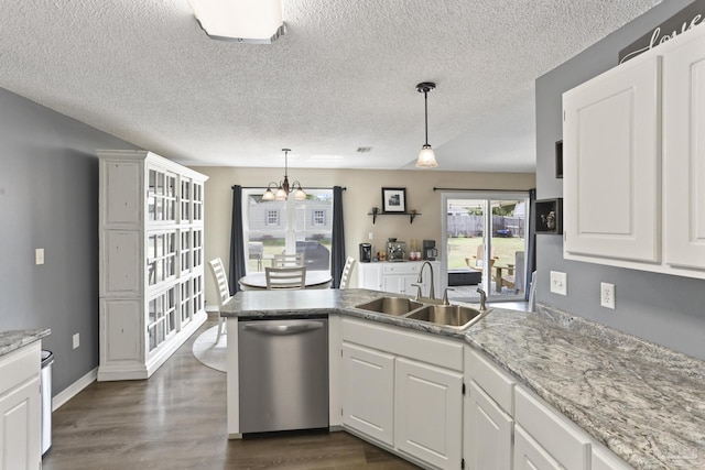kitchen with dishwasher, a sink, a peninsula, a chandelier, and white cabinets
