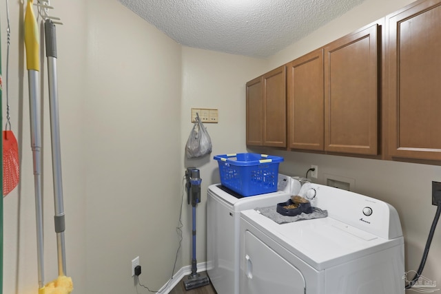 clothes washing area featuring a textured ceiling, cabinet space, and independent washer and dryer
