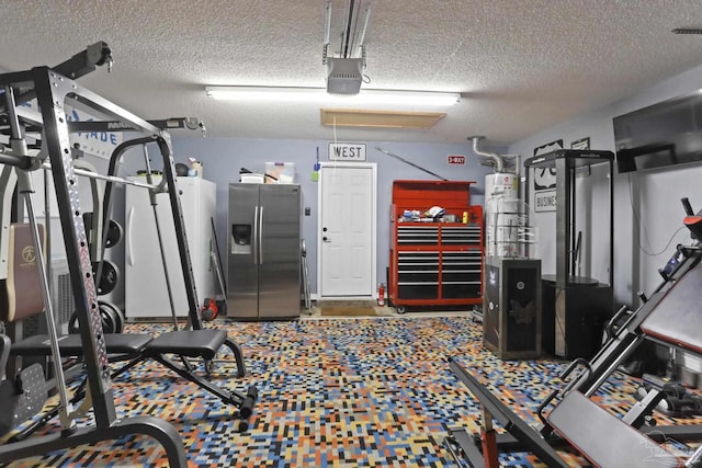 workout room with water heater, a textured ceiling, and a garage