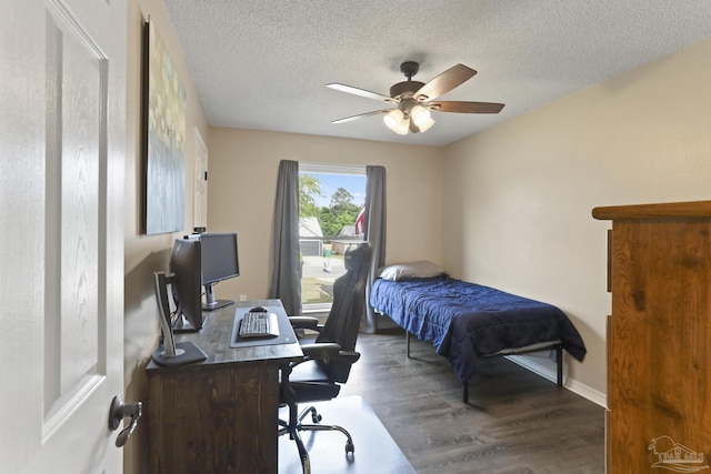 bedroom with ceiling fan, a textured ceiling, baseboards, and wood finished floors
