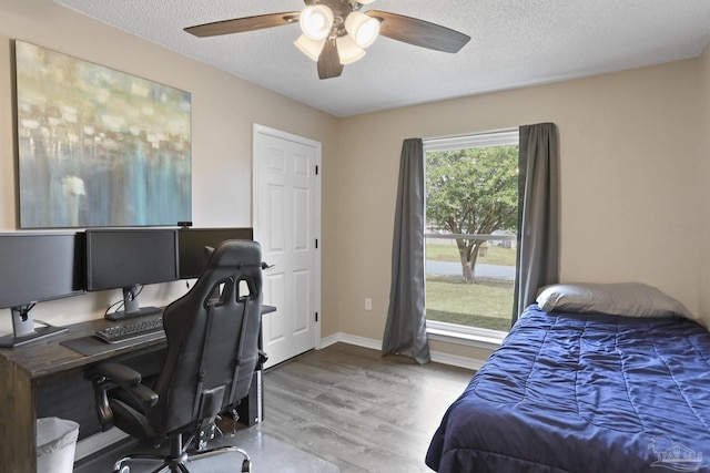 bedroom featuring a textured ceiling, wood finished floors, and a ceiling fan