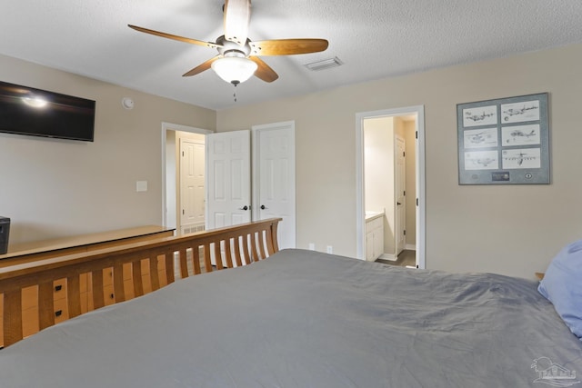 bedroom with connected bathroom, visible vents, baseboards, and ceiling fan