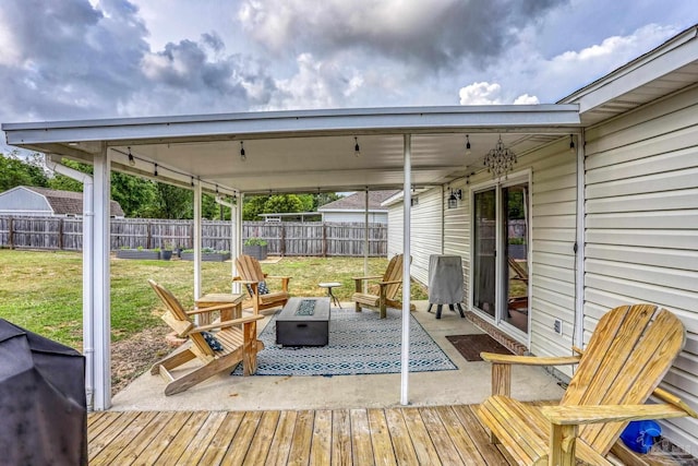 deck with a fire pit, fence, a lawn, and grilling area