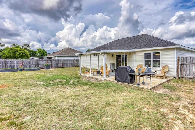 back of property featuring a yard, roof with shingles, and a fenced backyard