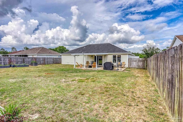 rear view of house featuring a lawn, a patio, and a fenced backyard