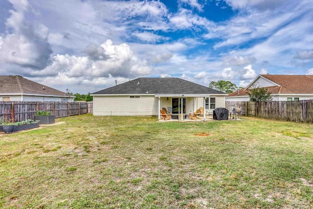 back of property featuring a lawn, a patio area, a garden, and a fenced backyard