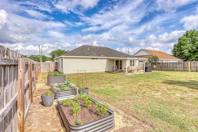 view of yard with a vegetable garden, a patio area, and a fenced backyard