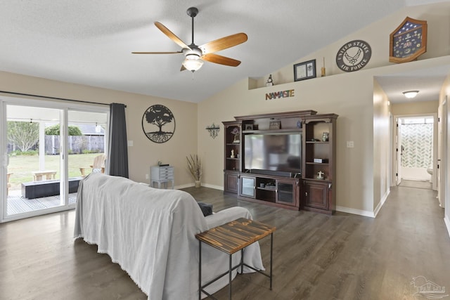 living room featuring baseboards, wood finished floors, ceiling fan, and vaulted ceiling