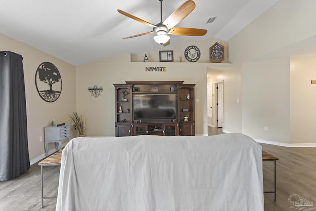 living area with vaulted ceiling, wood finished floors, visible vents, and ceiling fan