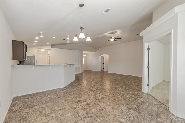 unfurnished living room with ceiling fan with notable chandelier and lofted ceiling