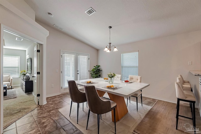 dining area with french doors, vaulted ceiling, a notable chandelier, and light tile patterned flooring