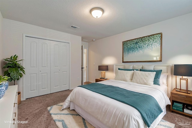 carpeted bedroom featuring a textured ceiling and a closet