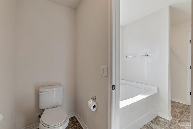 bathroom featuring a tub to relax in and toilet