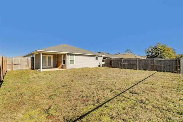 back of house with a lawn, a patio area, and french doors