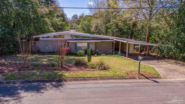 921 Lagoon Dr, Pensacola, FL 32505 - mid-century home featuring an attached carport, a front lawn, driveway, and stucco siding