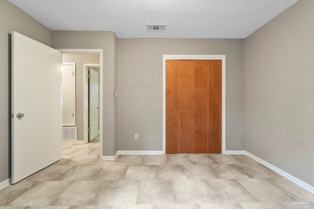 unfurnished bedroom with light tile patterned flooring, a closet, and a textured ceiling