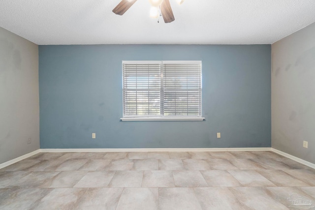 spare room featuring a textured ceiling, light tile patterned floors, and ceiling fan