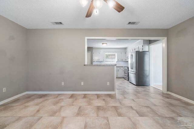 interior space featuring stainless steel fridge, white cabinets, and light tile patterned floors