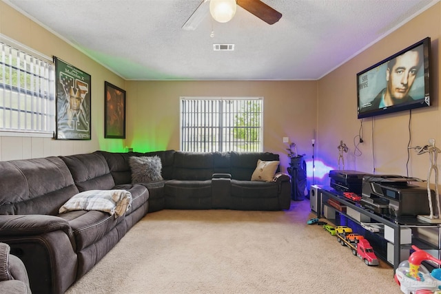 carpeted living room featuring a textured ceiling, crown molding, ceiling fan, and visible vents