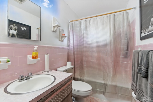 full bathroom with tile walls, toilet, wainscoting, and shower / bath combination with curtain