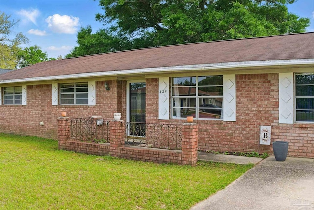 single story home featuring brick siding and a front yard