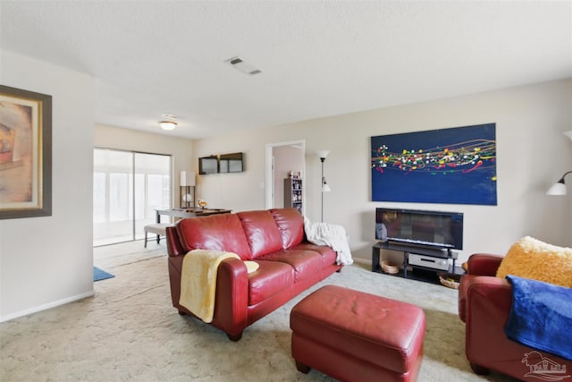 carpeted living area featuring baseboards and visible vents