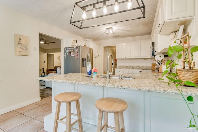 kitchen featuring appliances with stainless steel finishes, a textured ceiling, white cabinetry, and ceiling fan