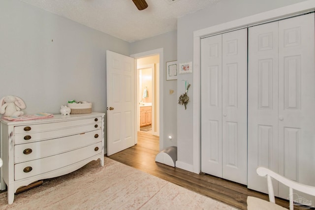 bedroom with ceiling fan, a closet, a textured ceiling, and hardwood / wood-style flooring