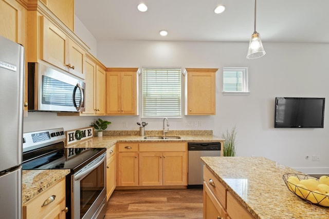kitchen with appliances with stainless steel finishes, a sink, light brown cabinets, light wood-style floors, and recessed lighting