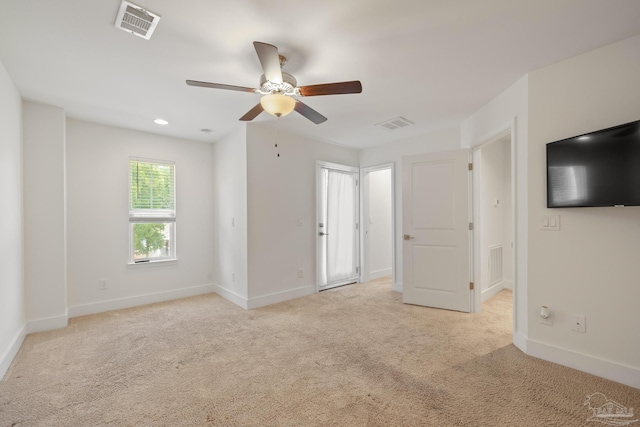 unfurnished room with ceiling fan, light colored carpet, and baseboards