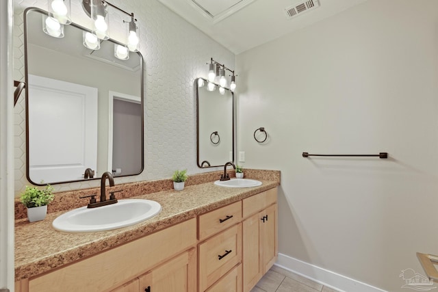 bathroom featuring tile patterned floors, double vanity, and baseboards