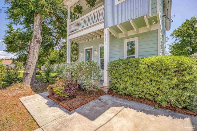 property entrance featuring a balcony and a porch