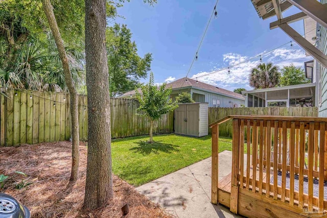 view of yard featuring a shed, an outbuilding, and a wooden deck
